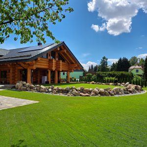 Seitliche Ansicht des Musterhauses Naturstammhaus Kanada von Holzbau Rustikal
