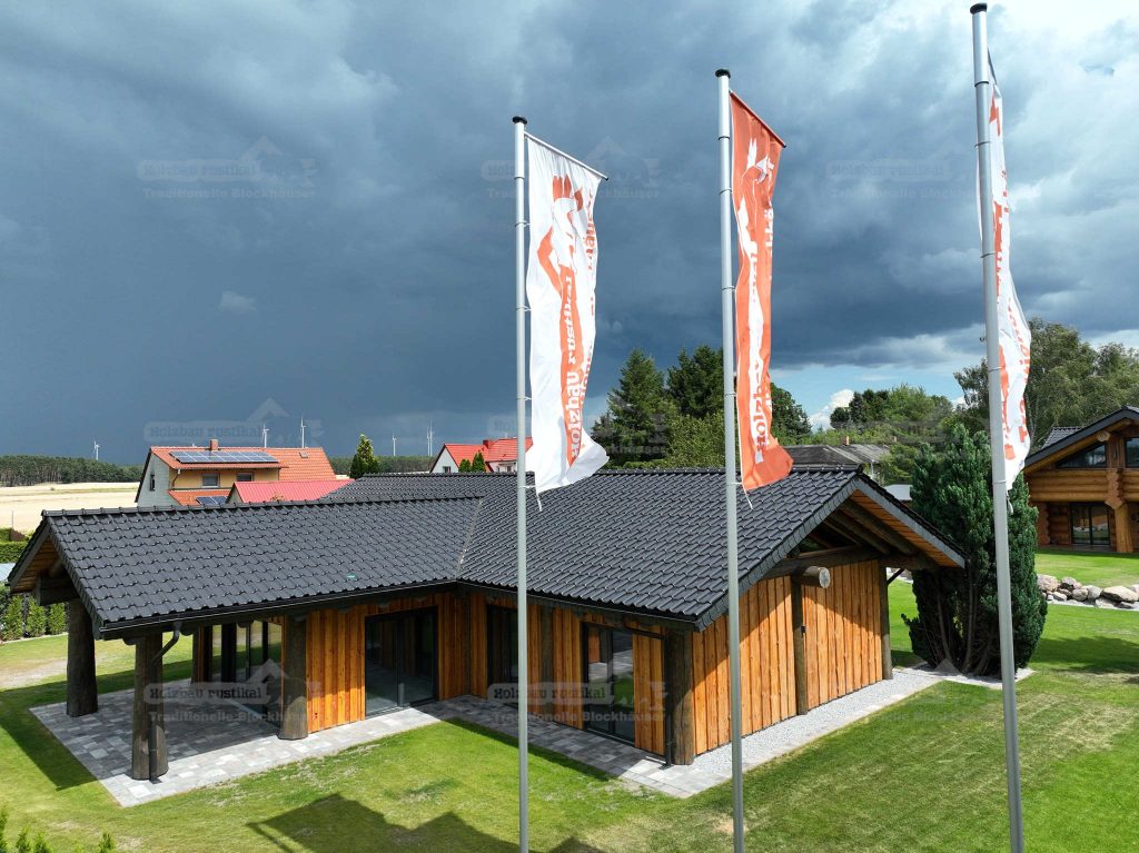 Vogelperspektive des Post-and-Beam Hauses Hamburg mit heller Putzfassade, Holzverkleidung, dunklem Ziegeldach und umliegender Grünfläche