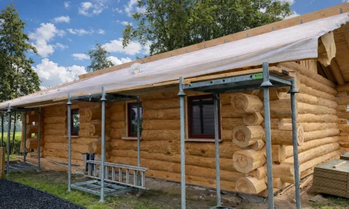 Blockhaus Ferienhaus Holland im Rohbau mit Dachaufbau und Geruest in der Seitenansicht