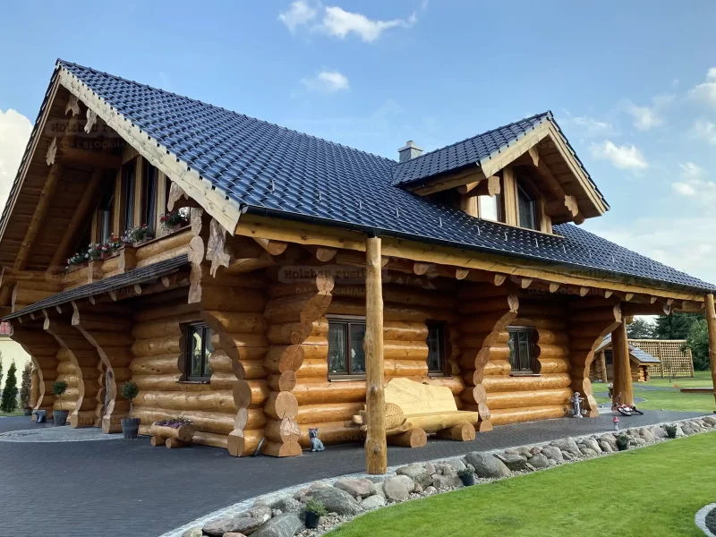 Seitliche Außenansicht Naturstammhaus Montreal mit rustikaler Blockbohlenbauweise