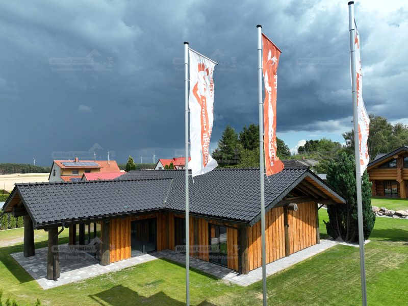 Vogelperspektive des Post-and-Beam Hauses Hamburg mit heller Putzfassade, Holzverkleidung, dunklem Ziegeldach und umliegender Grünfläche